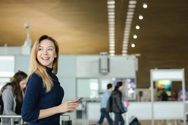 Caucásico chica charlando por teléfono inteligente en el aeropuerto hall . — Foto de Stock