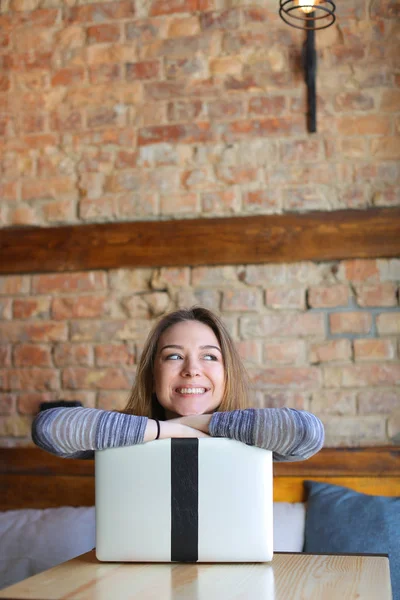 Mujer feliz sentada en la cafetería con portátil y sonriendo . — Foto de Stock