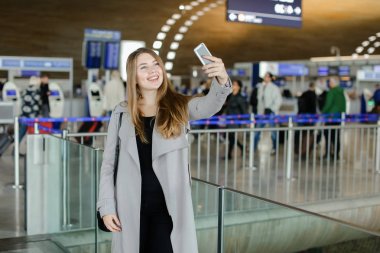 Genç kadın selfie smartphone ön kamera Havaalanı'nda yapma.