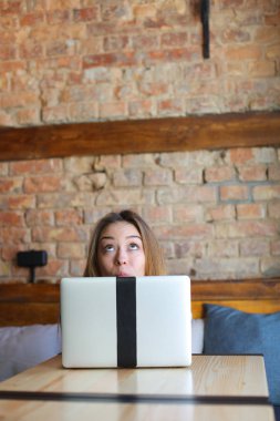 Kafede dizüstü bilgisayar ile zevk ve surat ferah kız.