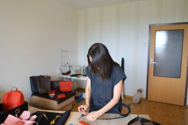 Malzemeler ve araçlar yakınındaki deri atelier çalışan beyaz craftswoman.