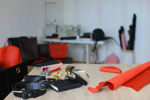 Leather atelier with materials, handmade wallets, belts and notebook inside.