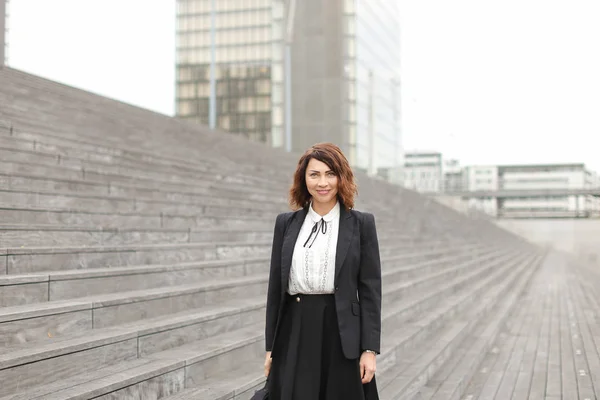 Secretario americano de pie en las escaleras con bolsa y edificios altos en el fondo . —  Fotos de Stock