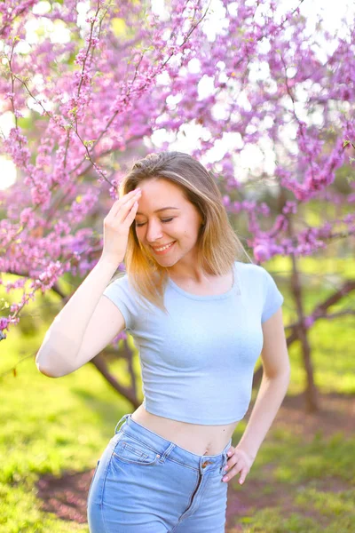 Menina sorridente feliz com fundo de árvore florescendo . — Fotografia de Stock