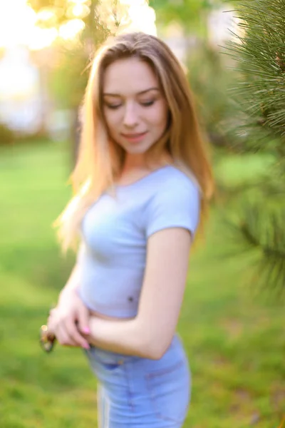 Sonhando modelo de foto feminina perto de madeira de cedro em fundo de grama verde . — Fotografia de Stock