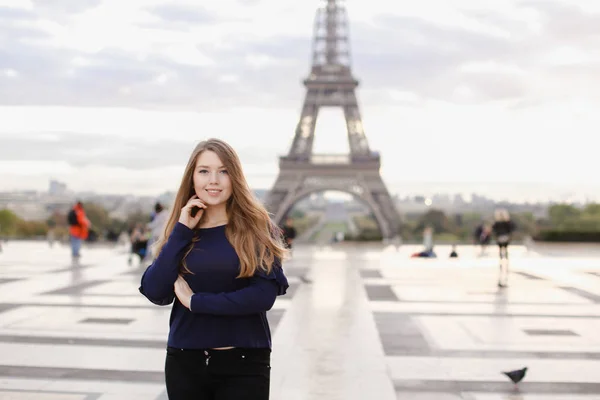 파리에 에펠 탑 백그라운드로 서 매력적인 여자. — 스톡 사진