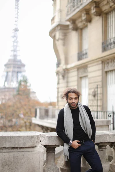 Hombre afroamericano de pie cerca de barandilla de hormigón con fondo de la Torre Eiffel en París . — Foto de Stock