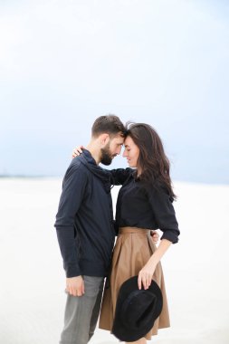 Oldukça mutlu bir kadın holding adam ve şapka beyaz kış arka planda tutarak giyiyor etek.