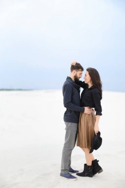 Etek, siyah bluz ve tutma şapka giyen adam kış kar arka planda sarılma beyaz kadın kişi.