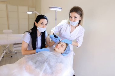 Kadın Başlarken profesyonel kalıcı gülümseyen güzellik uzmanı tarafından telafi etmek ve hemşire.