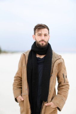 Avrupa iyi görünümlü erkek kişi Paltonu ve kaşkolünü beyaz kar arka planda duran giyen sakallı.
