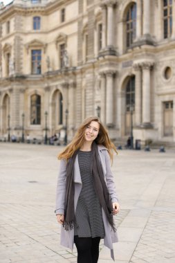 Gri ceket ayakta Paris'te Louvre yakınındaki genç kadın.