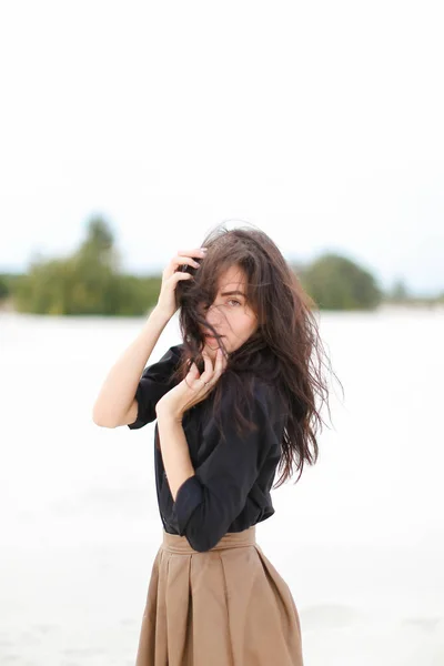 Caucásico chica usando negro camisa de pie en blanco monótono fondo . —  Fotos de Stock