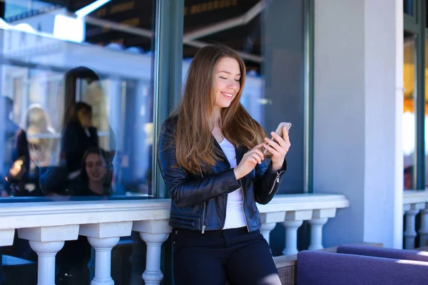 Gladden girl typing by smartphone at street cafe. — Stock Photo, Image