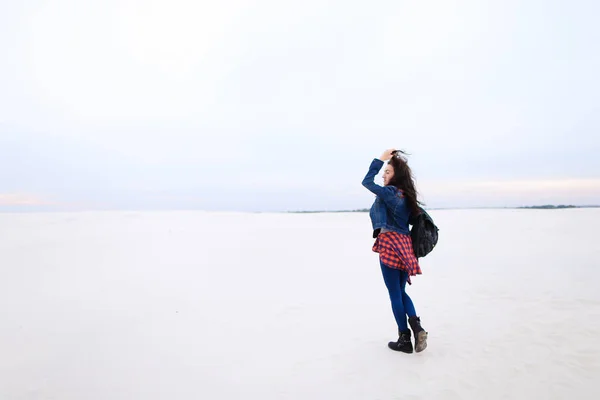 Menina caminhando no fundo da neve e vestindo jeans com saco . — Fotografia de Stock