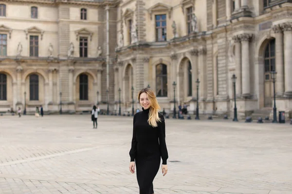 Dziewczyna ubrana w czarną sukienkę stojący w pobliżu Louvre Paris. — Zdjęcie stockowe