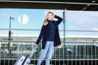 Valiz ile yürüyüş ve ceket giyen kadın kişi.