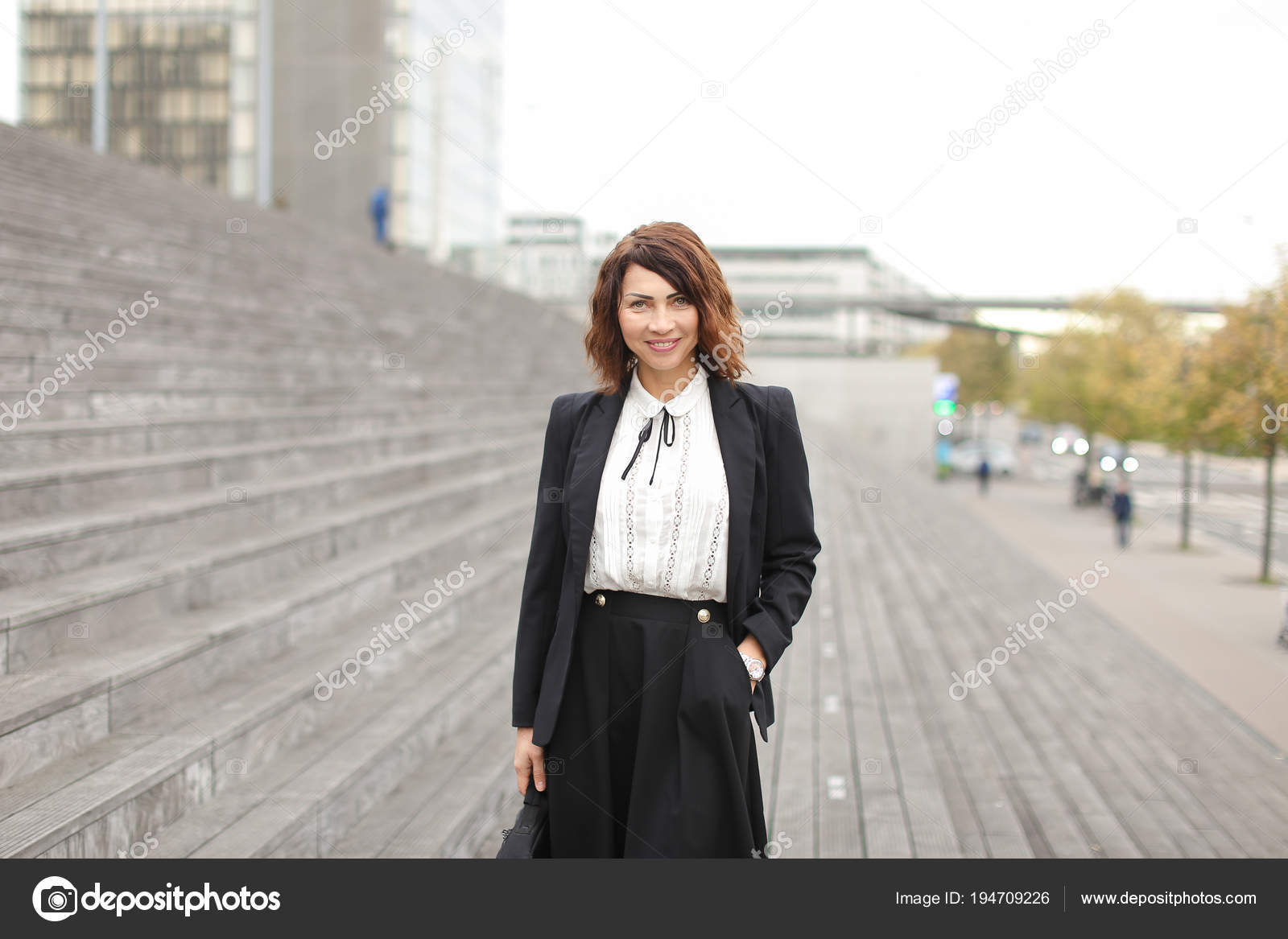 pretty female manager standing on stairs outside in high buildings buildings manager