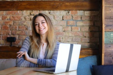 Internet kafede dizüstü tarafından kullanan Cheeerful kadın.