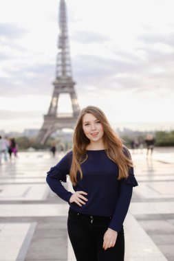 Paris'te Eyfel Kulesi arka planda duran güzel kadın kişi.