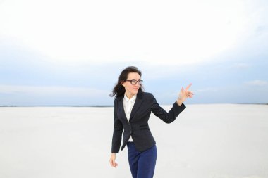 İşaret parmağı ile kar üzerinde duran ve ceket ve gözlük kız öğrenci.