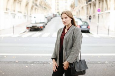 Şehirde sokak ve giyen cekette yürüyen genç kadın.