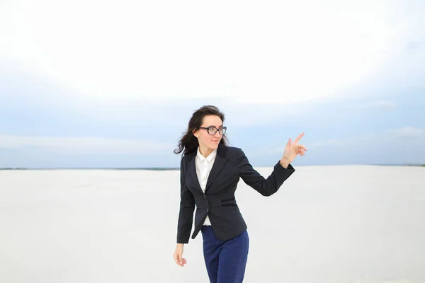 Estudiante de pie sobre la nieve con el dedo índice y con chaqueta y gafas . —  Fotos de Stock