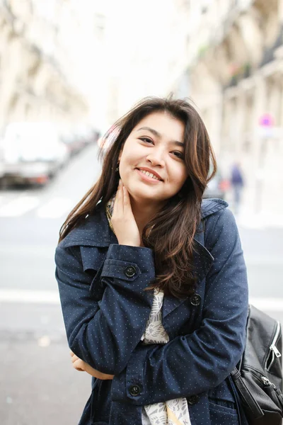 Asian smiling tourist standing in road background in Europe.