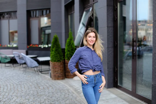 Trevlig kvinna som njuter av promenader i city och står nära byggnad. — Stockfoto