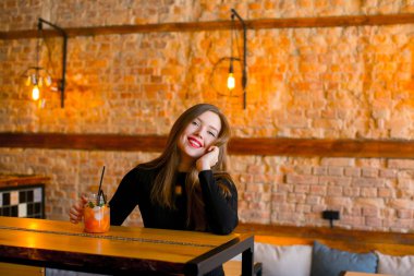 Limonata kafede fincan ile ahşap masa oturma ve rahatlatıcı memnun kız.