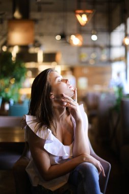 Kafede oturan ve Zümrüt ve etnik kot ile gümüş yüzüğü rahat kadın kişi.