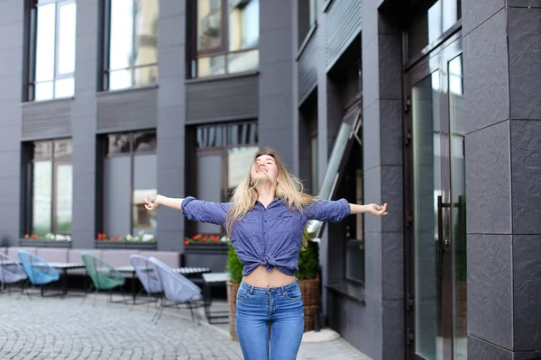 Hermosa chica disfrutando de caminar en la ciudad y de pie cerca del edificio . — Foto de Stock