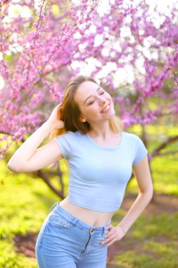 Çiçek açan ağaç arka plan ile ferah genç kız.