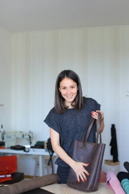 Gülümseyen kadın kahverengi deri el yapımı çanta atelier adlı yapım.