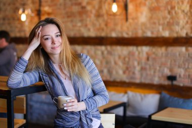 Memnun kız masanın sıradışı iç rahat kafe kapuçino fincan ile.