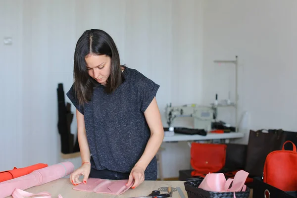 Europejskie kobiety Dokonywanie różowy skórzany portfel w domu atelier. — Zdjęcie stockowe