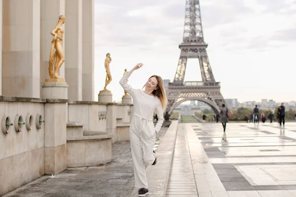 Nice woman walking on Trocadero square near gilded statues and Eiffel Tower. — Stock Photo, Image