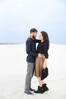 Etek, siyah bluz ve tutma şapka giyen adam kış kar arka planda sarılma beyaz mutlu kadın.
