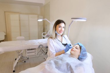 Kadın kozmetik güzellik uzmanı tarafından kaşları dövme getting dolap.