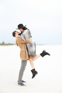 Beyaz adam şapka, ceket ve gri eşarp beyaz kar arka plan üzerinde giyen genç kadın tespit.