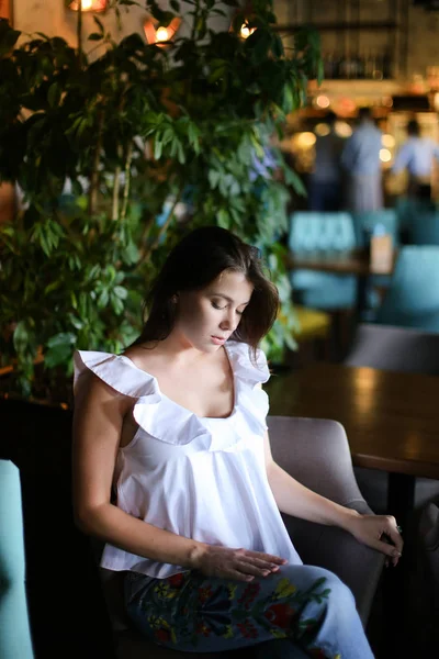 여자 옷 디자이너 카페에서 휴식 하 고 흰 블라우스와 함께 민족 청바지를 입고. — 스톡 사진