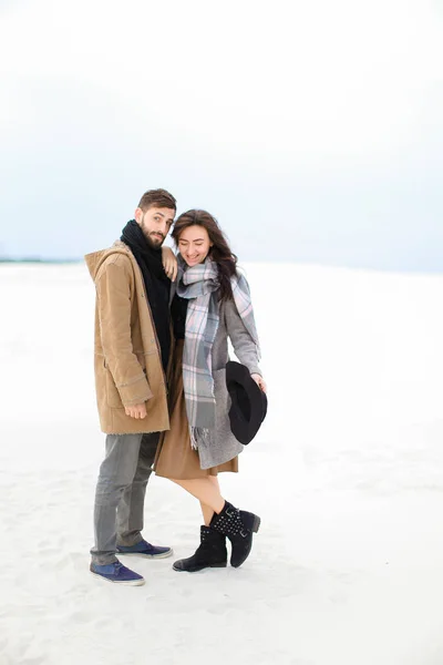 Mujer bonita con bufanda gris de pie con el hombre de abrigo, fondo blanco de invierno . — Foto de Stock