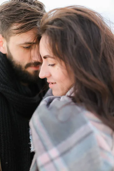 Junge kaukasische Frau und Mann, die sich umarmen und einen Schal tragen. — Stockfoto