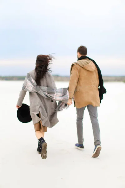 快乐的欧洲情侣在冬季漫步白色背景, 手牵着手穿大衣. — 图库照片