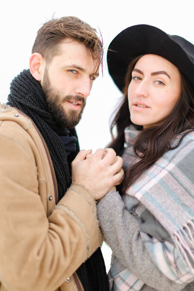 Портрет американской пары в шарфе и шляпе на белом фоне
.