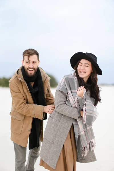 Europese vrouw en man dragen van jassen en sjaals die permanent in de winter sneeuw achtergrond. — Stockfoto