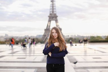 Paris'te Eyfel Kulesi arka planda duran genç kadın.