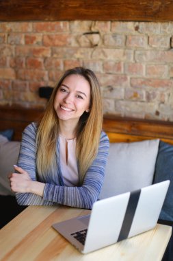 Kadın tablo yakınındaki ahşap sandalye üzerinde oturan ve bir fotoğraf için poz.