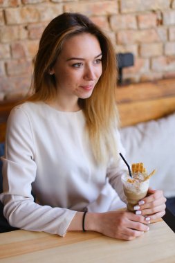 Genç model oturma ve sahip fotoğraf-oturum stilize Studio fotoğraf.