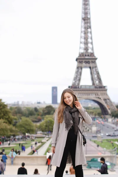 Kaukasiska kvinna i grå kappa stående med Eiffeltornet bakgrund i Paris. — Stockfoto